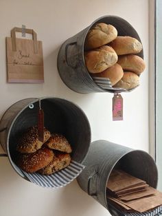 two metal buckets filled with pastries on top of a white counter next to a wooden bag