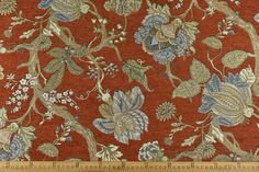 an orange and blue floral pattern on fabric with a ruler in front of it,