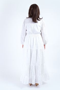 This White Hidden Button Ballon Sleeve Maxi Dress features long peasant sleeves with elastic for a comfortable fit. Dress has a subtle white floral design print. The button down design allows for easy wearing and a drawstring waist tie adds a touch of elegance. The full tiered maxi skirt is fully lined for added comfort. Made with 55% cotton and 45% polyester for a high quality and durable dress. Perfect for any occasion. Size & Fit Model Measurements (Model is wearing Size L) Bust: 39" Waist: 3 White Casual Peasant Dress For Spring, Long Sleeve Peasant Dress With Smocked Cuffs For Daywear, White Long Sleeve Prairie Dress For Spring, White Spring Maxi Dress With Elastic Waistband, White Casual Dresses With Bishop Sleeves, Casual White Bishop Sleeve Dresses, White Maxi Dress With Elastic Waistband For Spring, Spring Casual Long Sleeve Prairie Dress, White Long Sleeve Peasant Dress For Spring