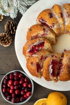 cranberry orange bundt cake on a white plate next to fresh cranberries