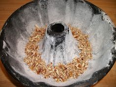 a metal bowl filled with granola on top of a wooden table