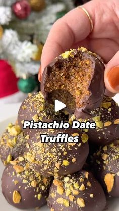 someone is holding up some chocolate truffles with pistachio toppings on them