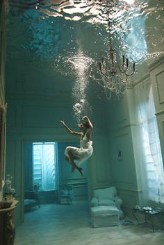 a woman floating in the air under water