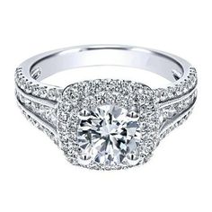 a white gold engagement ring with an intricate halo setting and round diamonds on the band