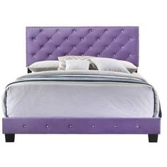 a bed with purple upholstered headboard and pillows