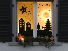 the window is decorated with christmas decorations and stars, while the sun shines through