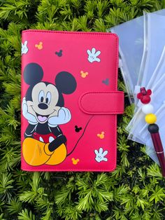 a minnie mouse passport case next to an umbrella