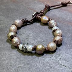 "These big cultured pearls give off their own glow!  Shades of peachy-pink, accented with smaller creamy pearls, a single handmade artisan sterling bead and soft dark brown leather, finished with a Hill Tribe Silver button.  Closure loops at approximately 6.5\"-7\", 7.5\"-8\", and 8.5\"-9\" give you lots of options if you want to pair this with your other faves.  (Extra loops can be cut off if not needed.) PLEASE NOTE: colors can vary, sometimes widely, from screen to screen.  I take photos under professional studio lighting as well as natural light to offer the best depiction of colors but colors may appear slightly different in person than on your screen.  Thank you for understanding.  Thanks so much for stopping by today, and for supporting small, artisan, and handcrafted goods business Adjustable Pink Pearl Bracelet With Pearl Drop, Pink Pearl Drop Bracelet, Hill Tribe Silver, Silver Button, A Hill, Mauve Pink, Silver Buttons, Pink Peach, Studio Lighting