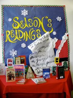 a red table topped with lots of books next to a blue and white sign that says season's readings