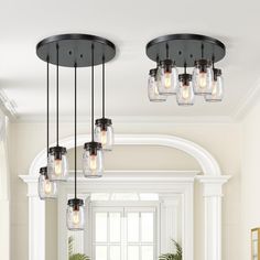 a dining room table and chairs with mason jars hanging from the chandelier above it