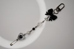 a black and white bracelet with charms on it's side, sitting on a plate