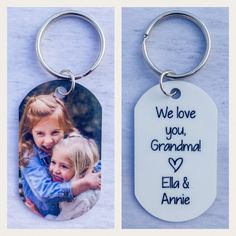 two key chains with pictures on them and the words, we love you, grandma