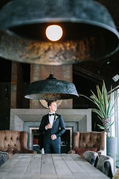 a man in a tuxedo standing next to a table