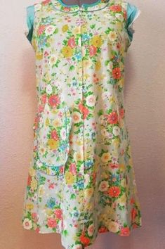 "This is a super groovy floral covered 1960s cotton apron in blue, green, pink, white and yellow. This will surely make your kitchen time more fun and enjoyable.  This apron has short little blue silky sleeves. Don't know what the fabric is but its totally different than any of the other materials used on the entire garment. The body of the piece feels like linen almost. I think its wonderful because its a very cheerful piece, it has a large and quite deep pocket, frills, various types of trim, and is 100% handmade. It also has a cute large plastic purple flower attached to the zipper to be used as a pull. The zipper is a metal YKK and runs all the way down the front center to the hip line.  *This piece has been dry cleaned and hand steamed. Measurements: Length- 36\" Shoulder- 15\" Sleeve 1960s Pinafore Dress, Mid-century Cotton Lined Dress, Multicolor Mod Dress With Floral Print, Multicolor Cotton Mod Dress, 1960s Apron, Corduroy Dress, Cotton Apron, Apron Dress, Sewing Rooms