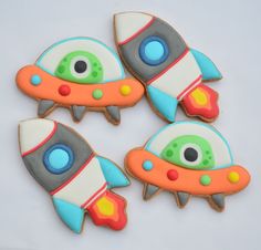 three decorated cookies in the shape of spaceships