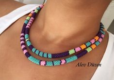 a woman wearing a multi - colored beaded necklace with two rows of beads on it