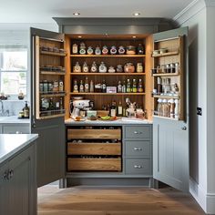 an open cabinet in the middle of a kitchen filled with bottles and condiments