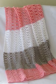 a crocheted blanket on a bed with white sheets and pink trimmings