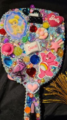 there are many different items on this decorative item in the shape of a tree that has been decorated with sequins and beads