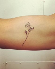 a small flower tattoo on the arm