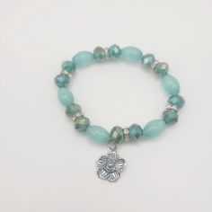 Gorgeous piece is made with Teal beads and silver flower charm.  Every bracelet is carefully designed and packaged with love. What makes our bracelets stand out from others, is the quality and durability of them. Our bracelets are made with two strands and a secure knot to give it strength.  Orders that are placed will be shipped out 1-2 business days. We offer 2 shipping options. We ship world wide.  Handle with care. Charm bracelet are not meant to be worn in physical activities, such as playing sports, or showering. Sizing is 7 inches and width is 10mm. Secure Knot, Flower Charm Bracelet, Bracelet Stand, Teal Flowers, Playing Sports, Flower Charm, Silver Flowers, Physical Activities, Charm Bracelets