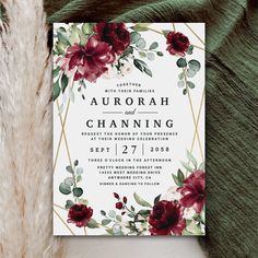 a wedding card with burgundy flowers and greenery