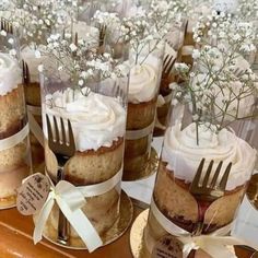 there are many desserts on the table with forks in each cupcake, which is decorated with baby's breath flowers