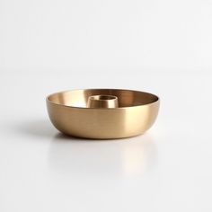 a gold bowl sitting on top of a white table