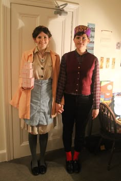 two women standing next to each other in front of a door wearing clothes and shoes