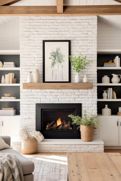 a living room with a fire place and bookshelves on the wall above it