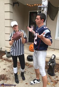 two people dressed as football players in front of a house