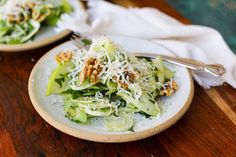 two plates filled with salad on top of a wooden table