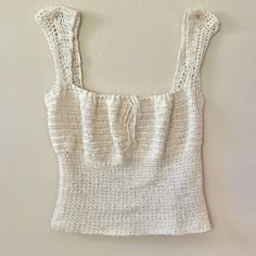 a crocheted top hanging on the wall