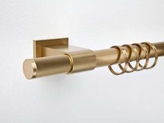 a gold metal curtain rod on a white wall