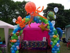 an octopus and starfish balloon arch in the shape of a tent at a children's birthday party