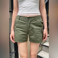 Mid-Rise Cargo Shorts With Adjustable Waist Buckles, Front And Back Pockets And Two Button Pockets On The Side. Fabrics: 100% Cotton Measurement: 9" (22 Cm) Rise, 4" (10 Cm) Inseam, 29" (72 Cm) Waist Made In: China Casual Mid-rise Cotton Cargo Shorts, Mid-rise Cotton Cargo Shorts With Pockets, Green High-waisted Cargo Shorts, High-waisted Green Cargo Shorts, Casual Mid-rise Cargo Shorts With Pockets, Casual Mid-rise Cotton Shorts, Casual Green Short Length Cargo Pants, Mid-rise Cotton Cargo Shorts With Side Pockets, Utility Mid-rise Shorts With Side Pockets