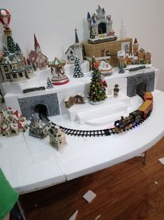 a model train set on display in a room with wooden flooring and white walls