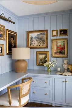 a room with blue painted walls and pictures on the wall, along with a desk