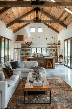 a living room filled with furniture and lots of wood ceilinging on top of a wooden floor