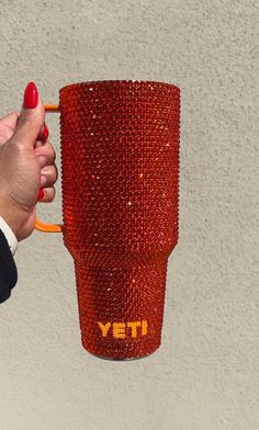 a hand holding a red yeti coffee cup