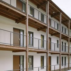 an apartment building with multiple balconies and wooden railings on the side walk