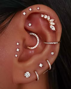 a woman's ear with three different piercings