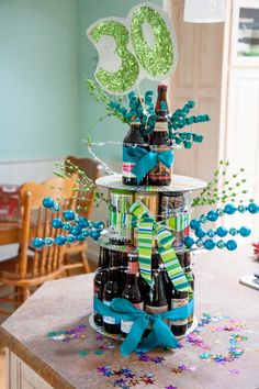 a birthday cake made out of beer bottles and ribbons with the number 80 on top