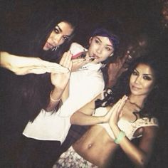 three young women posing for the camera with their hands in the air