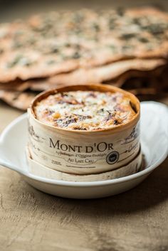 two bowls of food sitting on top of a white plate next to some flatbreads