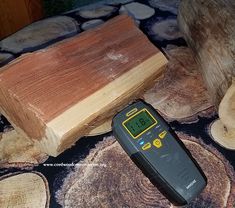 a digital thermometer sitting on top of a table next to wood slices and logs