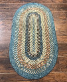 a blue rug with an oval design on the floor in front of a wooden floor