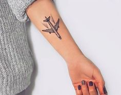 a woman's arm with a tattoo on it and an airplane in the middle