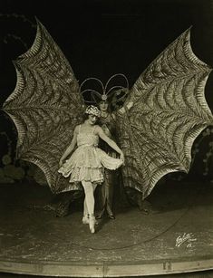 an old photo of two women dressed in costumes with wings attached to their heads and legs