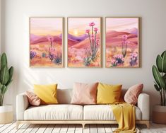 three paintings hang on the wall above a couch